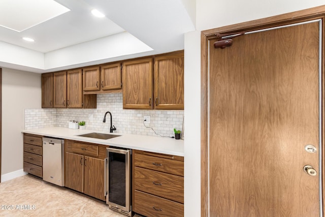 kitchen with beverage cooler, dishwasher, sink, and decorative backsplash