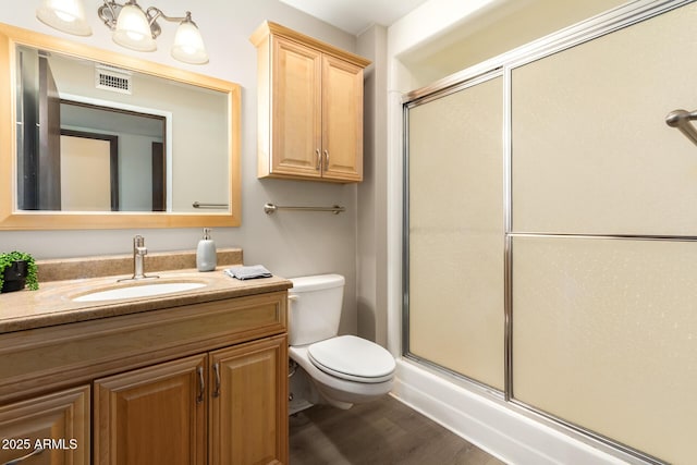 bathroom with vanity, hardwood / wood-style floors, toilet, and walk in shower