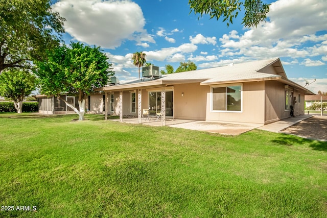 rear view of house featuring cooling unit, a yard, and a patio