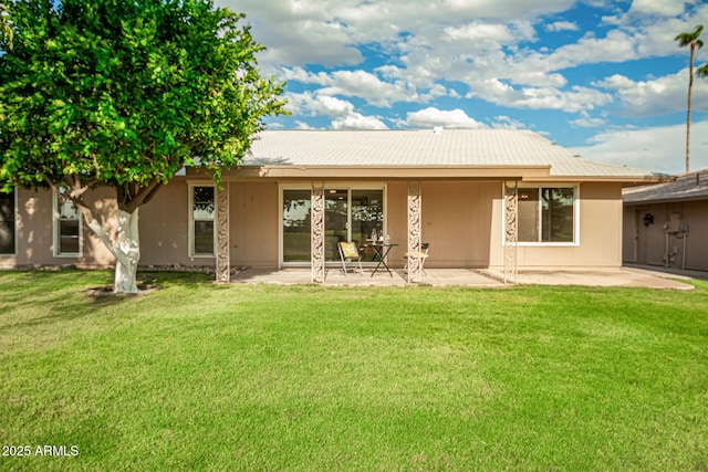 back of house featuring a lawn and a patio area