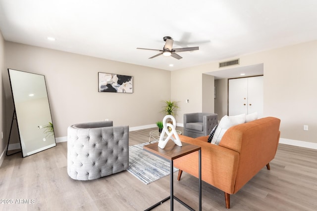 living room with light hardwood / wood-style flooring and ceiling fan