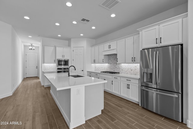 kitchen featuring appliances with stainless steel finishes, light hardwood / wood-style flooring, white cabinetry, and sink