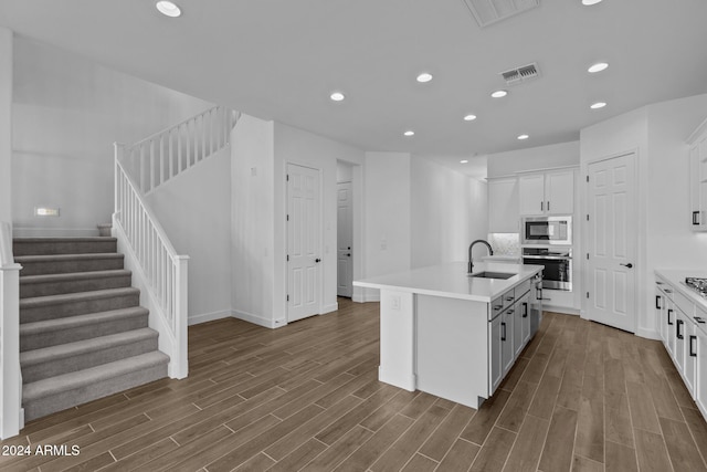 kitchen with sink, light wood-type flooring, an island with sink, and appliances with stainless steel finishes