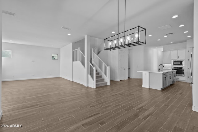 unfurnished living room featuring dark hardwood / wood-style flooring and sink