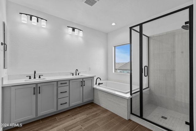 bathroom with hardwood / wood-style floors, vanity, and separate shower and tub