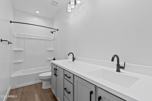 full bathroom featuring hardwood / wood-style flooring, vanity, toilet, and shower / washtub combination