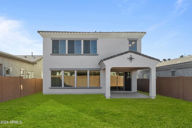 rear view of house featuring a yard and a patio