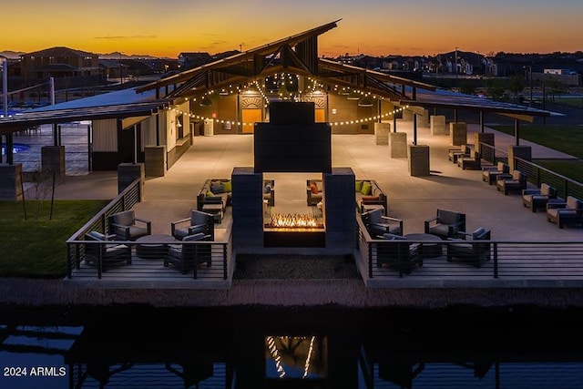 back house at dusk with outdoor lounge area and a patio area