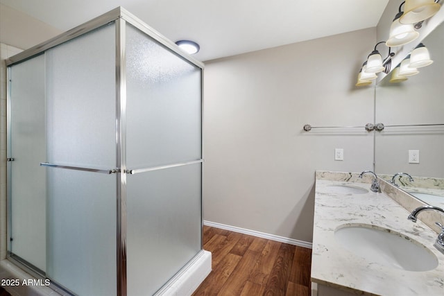 bathroom with vanity, hardwood / wood-style flooring, and a shower with door