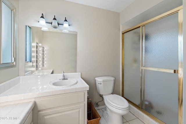 bathroom with a shower with door, tile patterned floors, toilet, and vanity