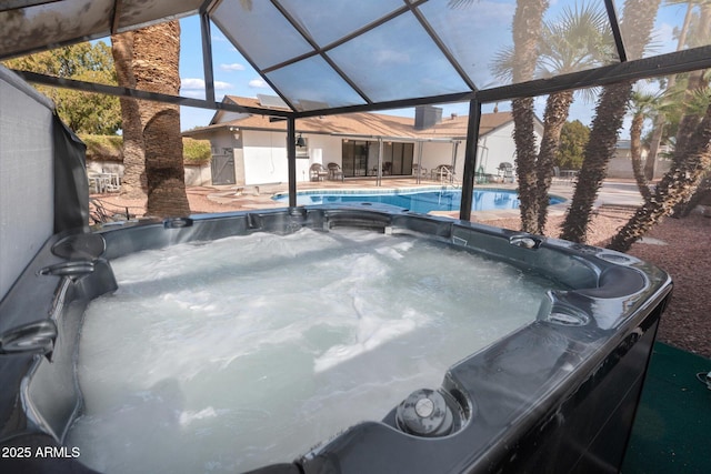 exterior space with a patio, glass enclosure, and a hot tub