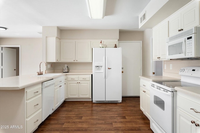 kitchen with kitchen peninsula, sink, white cabinetry, white appliances, and dark hardwood / wood-style floors