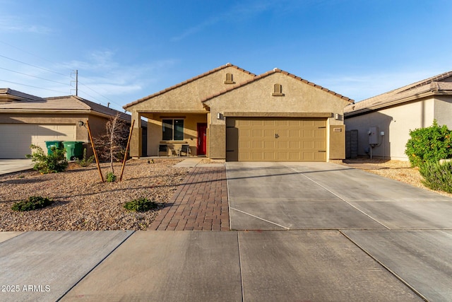 view of front of house with driveway, a tiled roof, a garage, and stucco siding