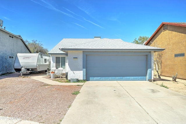 ranch-style home with driveway, a shingled roof, and stucco siding