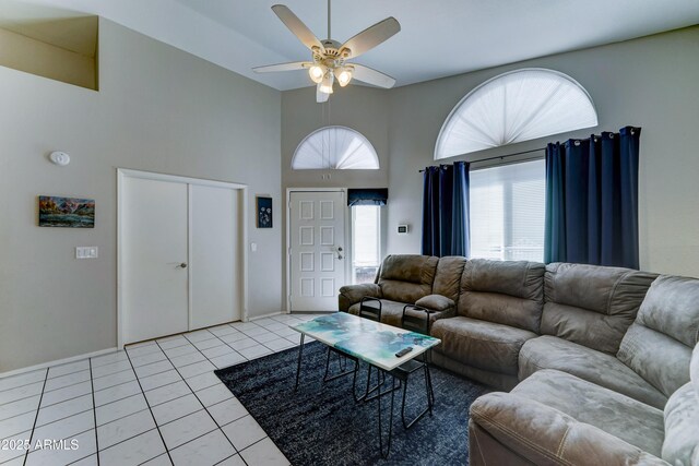 living area featuring light tile patterned flooring, a high ceiling, and ceiling fan
