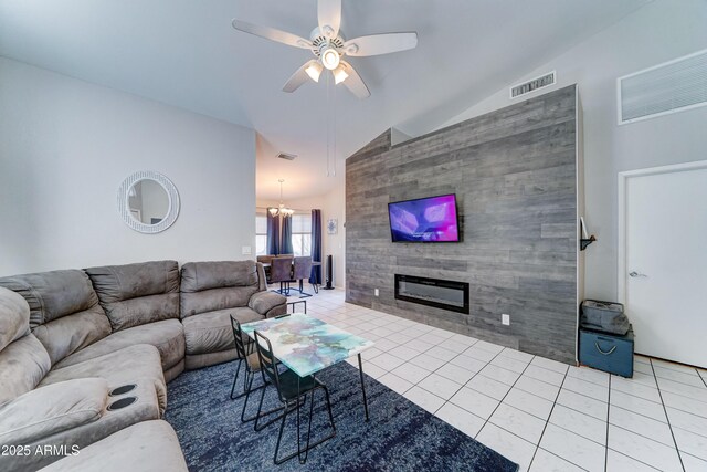 tiled living room featuring visible vents, lofted ceiling, and ceiling fan with notable chandelier