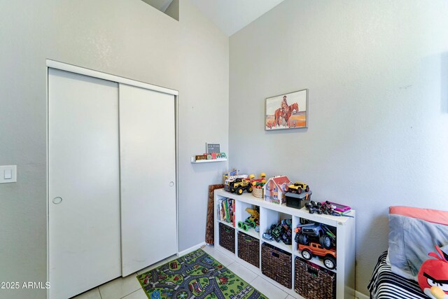 rec room with tile patterned floors, vaulted ceiling, and baseboards