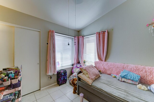 bedroom with tile patterned floors, baseboards, and lofted ceiling