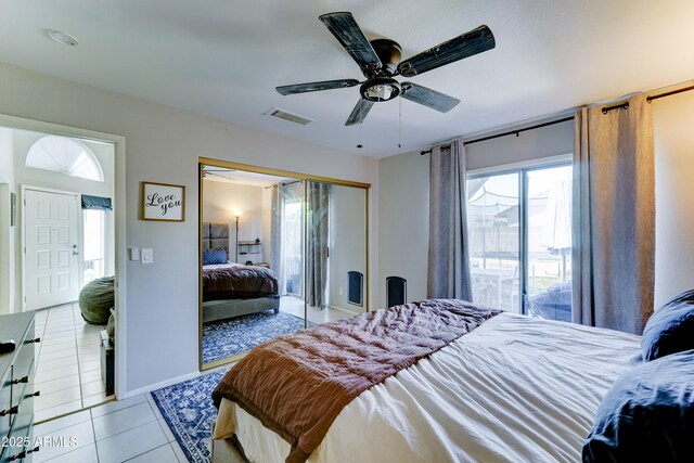 bedroom featuring a ceiling fan, visible vents, baseboards, a closet, and light tile patterned flooring