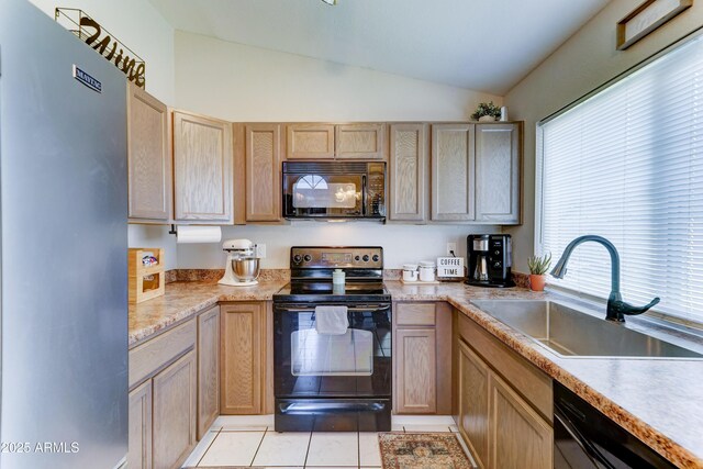 kitchen with lofted ceiling, light countertops, a sink, light tile patterned floors, and black appliances