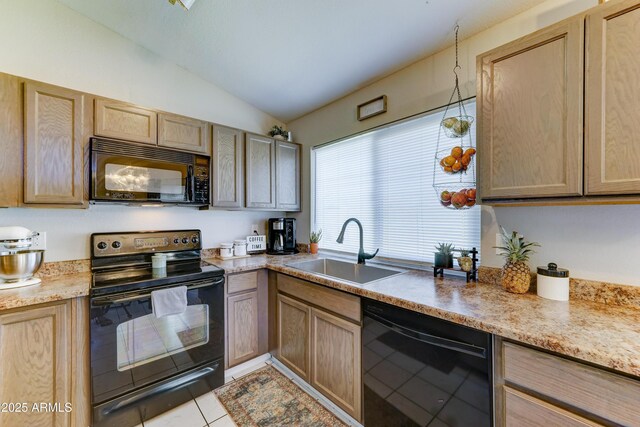kitchen featuring light brown cabinetry, vaulted ceiling, a sink, and black appliances