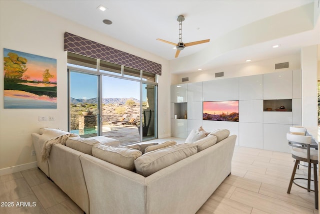 living area with visible vents, a mountain view, baseboards, and ceiling fan