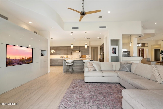 living area featuring recessed lighting, visible vents, light wood-style flooring, and ceiling fan