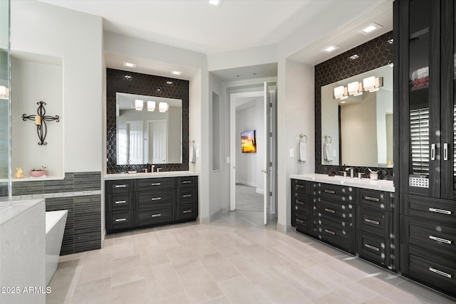 full bathroom featuring tile patterned floors, two vanities, and a tub