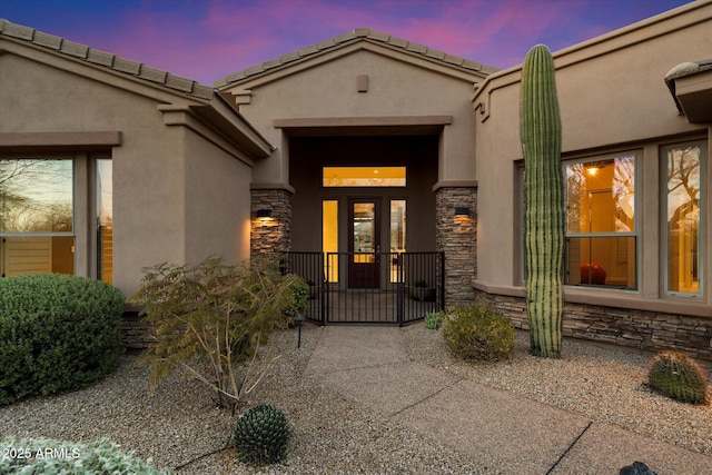 entrance to property with stone siding and stucco siding