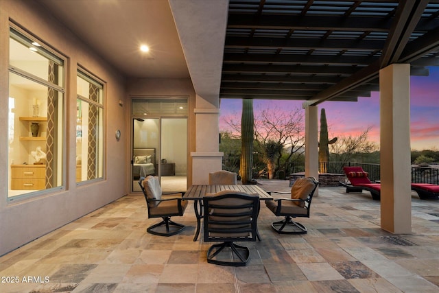 patio terrace at dusk with outdoor dining space and fence