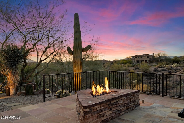 patio terrace at dusk featuring a fire pit