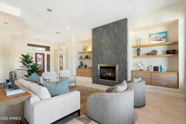 living room with recessed lighting and a large fireplace