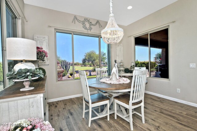 dining space with a healthy amount of sunlight, a chandelier, and dark wood-type flooring