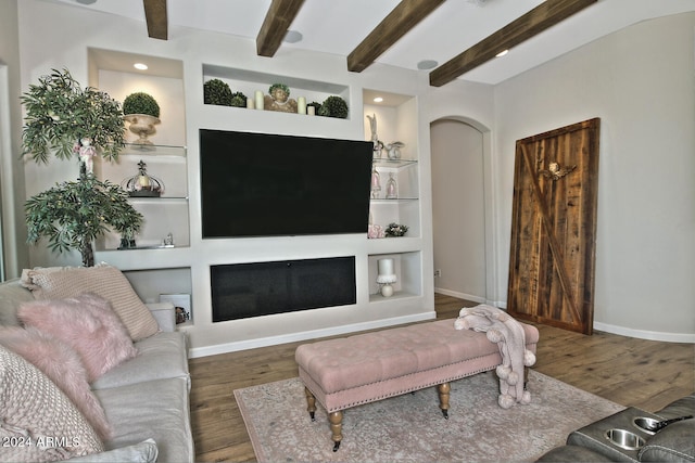 living room featuring wood-type flooring, a fireplace, and beamed ceiling