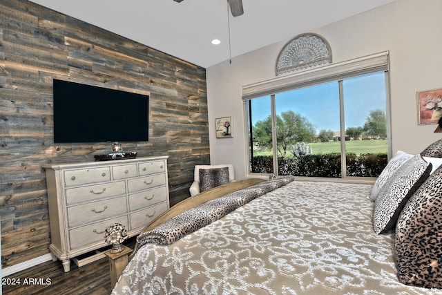 bedroom featuring ceiling fan, wooden walls, and wood-type flooring