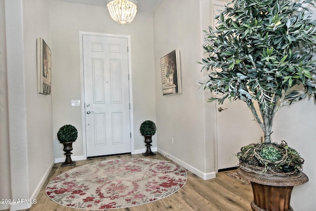 entrance foyer with light hardwood / wood-style floors and a notable chandelier