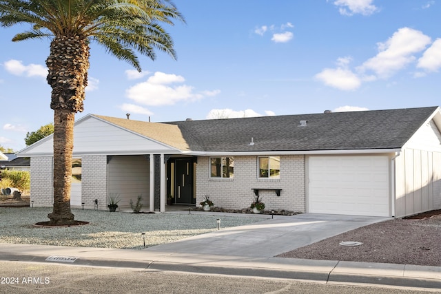 single story home with a garage, brick siding, driveway, and roof with shingles