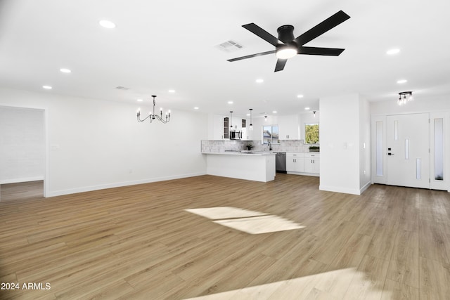 unfurnished living room featuring light wood finished floors, ceiling fan with notable chandelier, visible vents, and recessed lighting