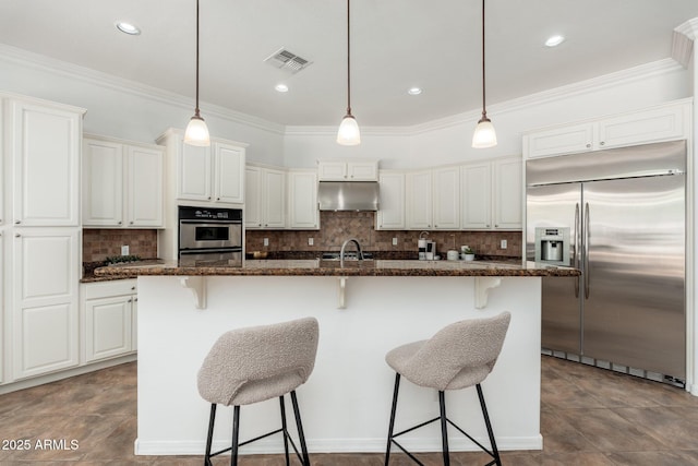 13034 W Krall Ct, Glendale, AZ 85307 - kitchen featuring stainless steel appliances, crown molding, decorative backsplash, under cabinet range hood, and a breakfast bar area