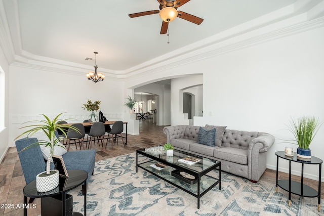 13034 W Krall Ct, Glendale, AZ 85307 - living room featuring arched walkways, a tray ceiling, a chandelier, a ceiling fan, and crown molding