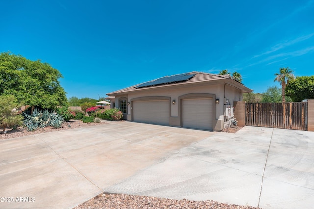 13034 W Krall Ct, Glendale, AZ 85307 - view of home's exterior with concrete driveway, roof mounted solar panels, stucco siding, and an attached garage