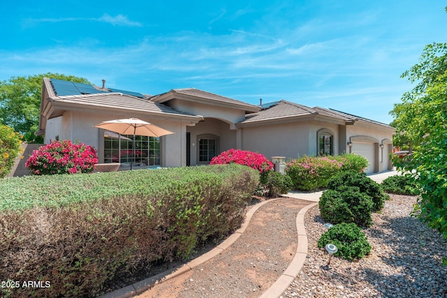 13034 W Krall Ct, Glendale, AZ 85307 - view of front facade with an attached garage, stucco siding, roof mounted solar panels, and a tiled roof