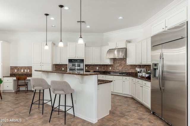 13034 W Krall Ct, Glendale, AZ 85307 - kitchen with appliances with stainless steel finishes, under cabinet range hood, ornamental molding, a kitchen breakfast bar, and white cabinets