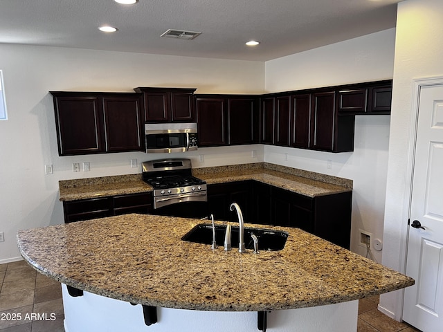 4548 E Carob Dr, Gilbert, AZ 85298 - kitchen featuring appliances with stainless steel finishes, tile patterned floors, light stone countertops, a sink, and recessed lighting