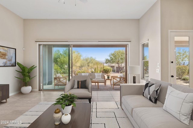 tiled living room featuring ceiling fan and plenty of natural light