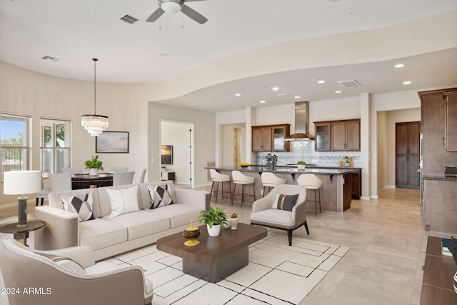 living room with ceiling fan with notable chandelier and light tile patterned floors