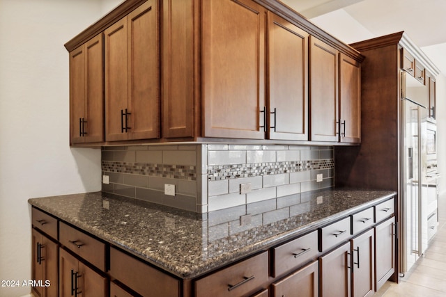 kitchen featuring dark stone counters and backsplash