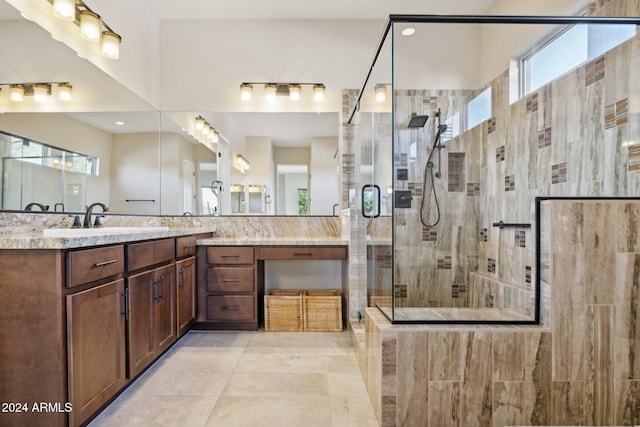 bathroom with vanity, a shower with door, plenty of natural light, and tile patterned flooring