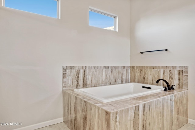 bathroom featuring tiled bath and tile patterned flooring