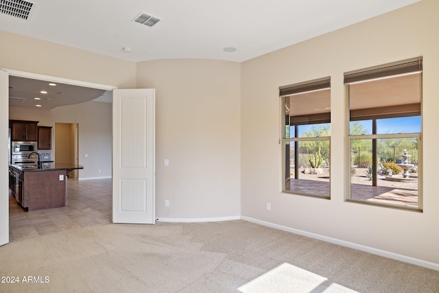 spare room featuring light carpet